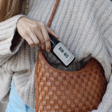 Model putting hand lotion into purse