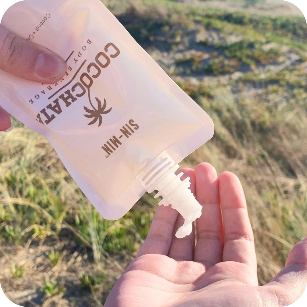 Close up of Cocochata being dispensed into models hands with sandy hills in the background