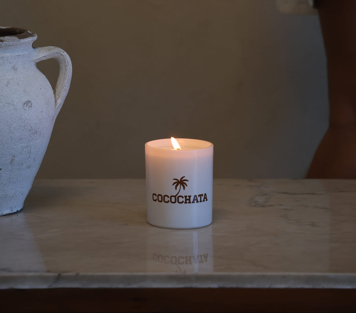 Image of a candle on a table next to a water jug