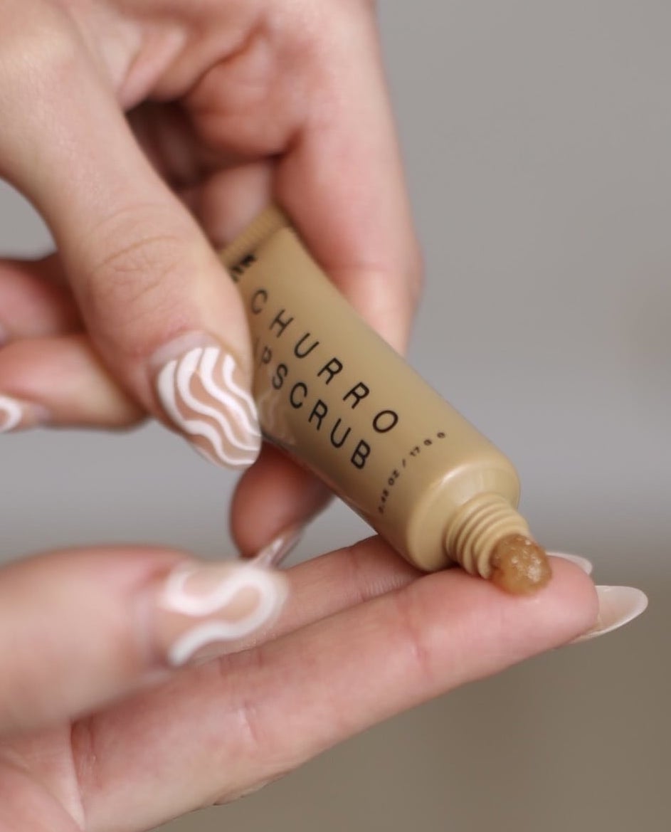 hand model putting churro lip scrub on her finger